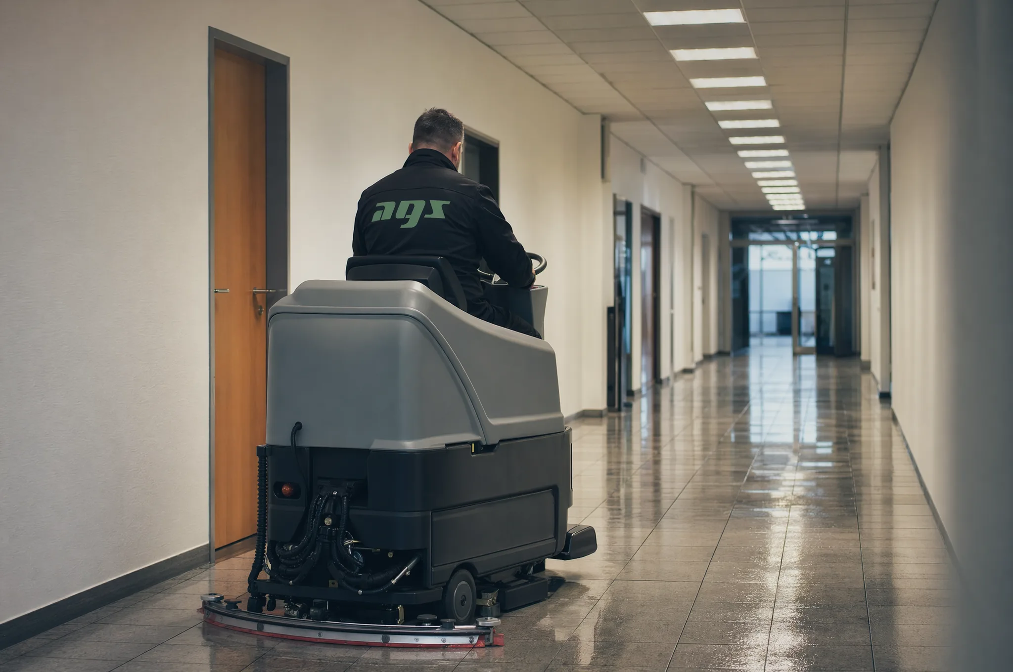 Maschinelle Grundreinigung eines Gebäudeflurs mit einer Aufsitz-Scheuersaugmaschine von AGS
